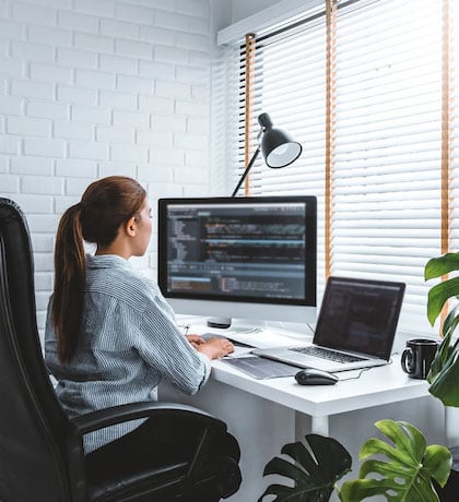 woman working at desk with computers