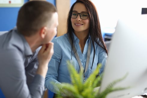 Woman and man looking at computer software in office setting